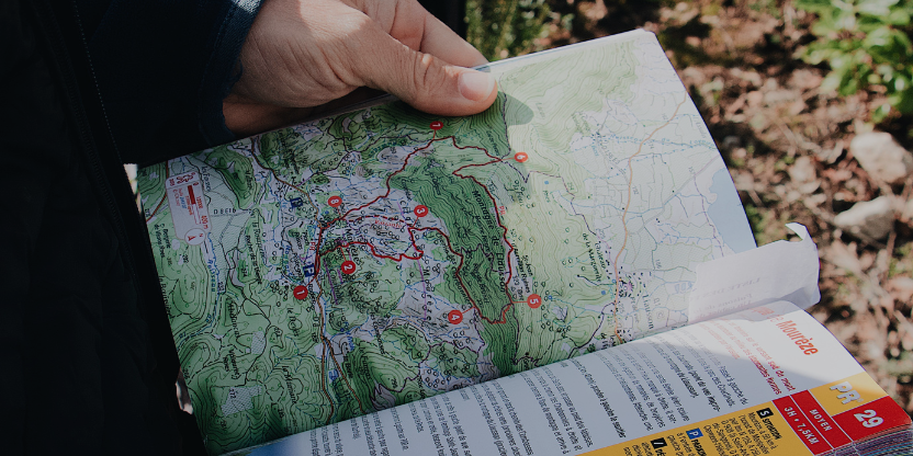 Hand holding a detailed eco trail map for jungle trekking in Borneo Malaysia