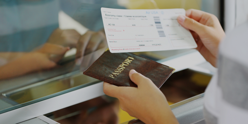 Traveler showing passport and boarding pass at check-in counter for trip to Malaysia