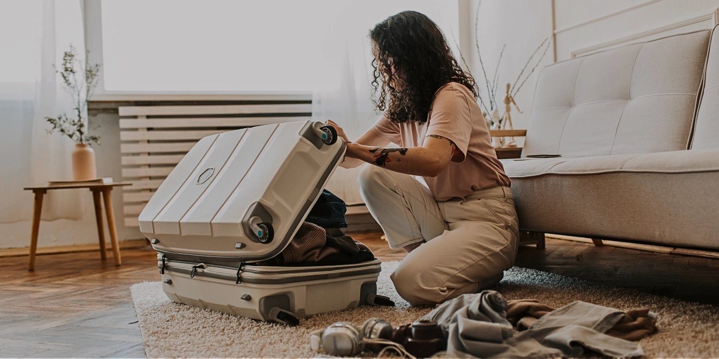 A woman organizing eco-friendly travel essentials while packing for a responsible trip to Sepilok