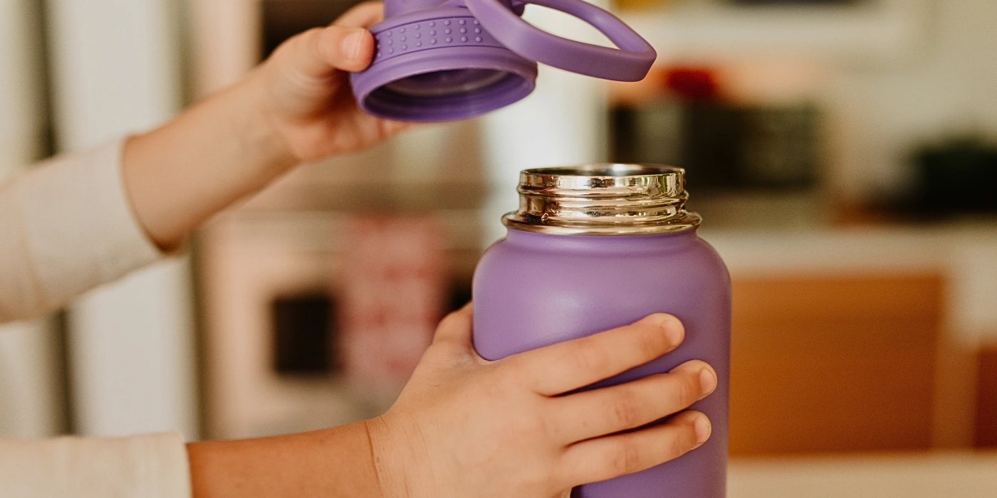 Traveler holding a reusable water bottle