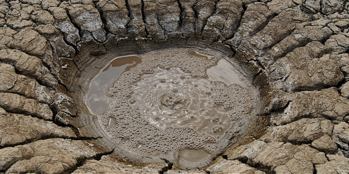 Close-up of Tabin’s mud volcano with round, active bubbles forming on the surface of the muddy crater