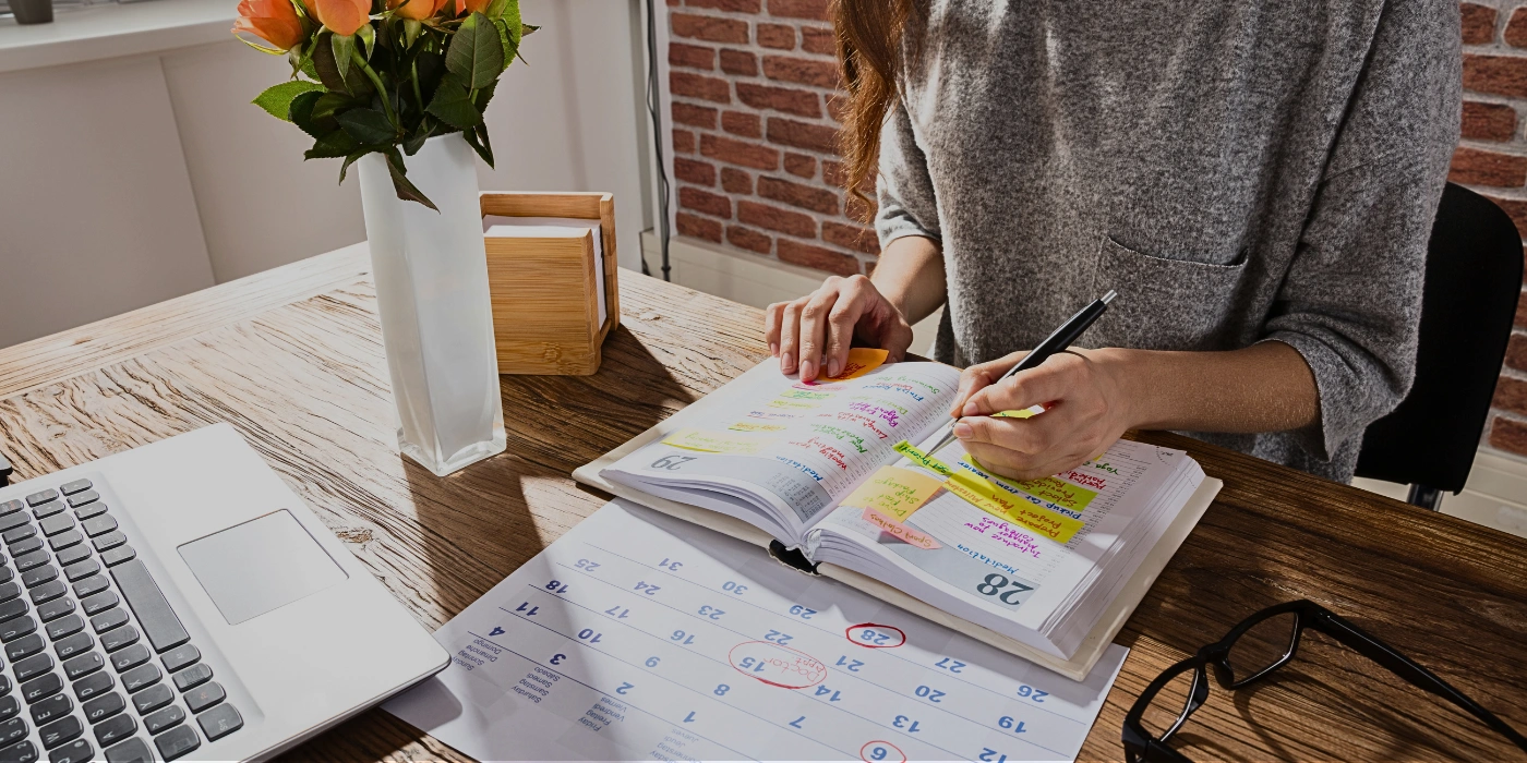 Woman reviewing her planner and calendar, scheduling a visit to Tabin during the ideal travel season