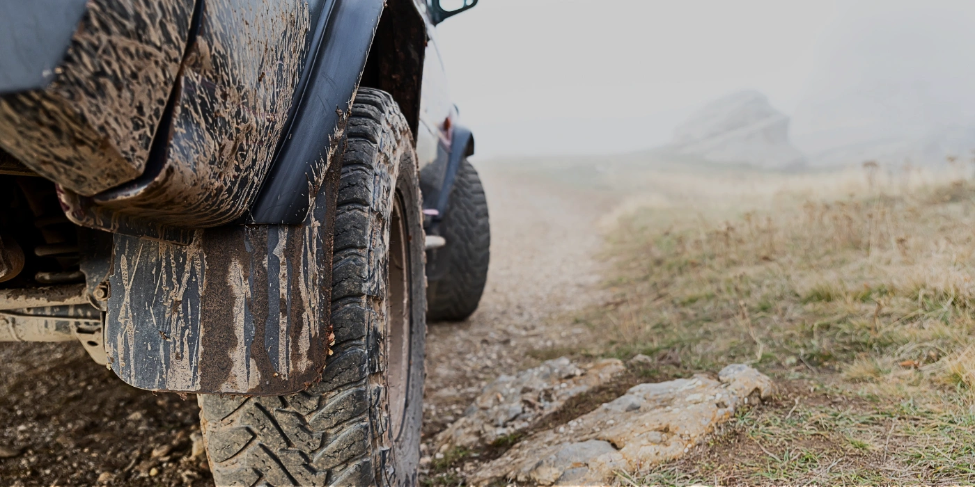 4WD vehicle driving on a muddy jungle track en route to Tabin or Danum Valley in Sabah