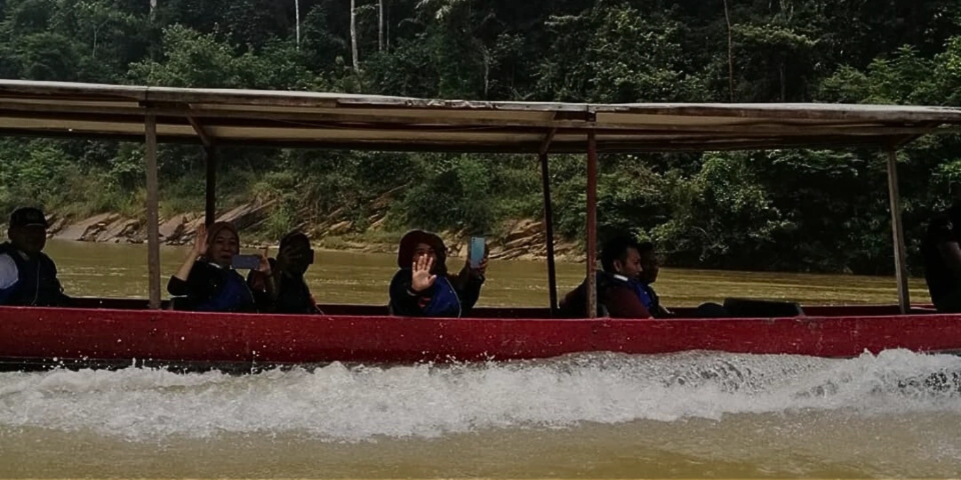 A group of people on a longboat enjoying a rapid shooting tour together in Taman Negara