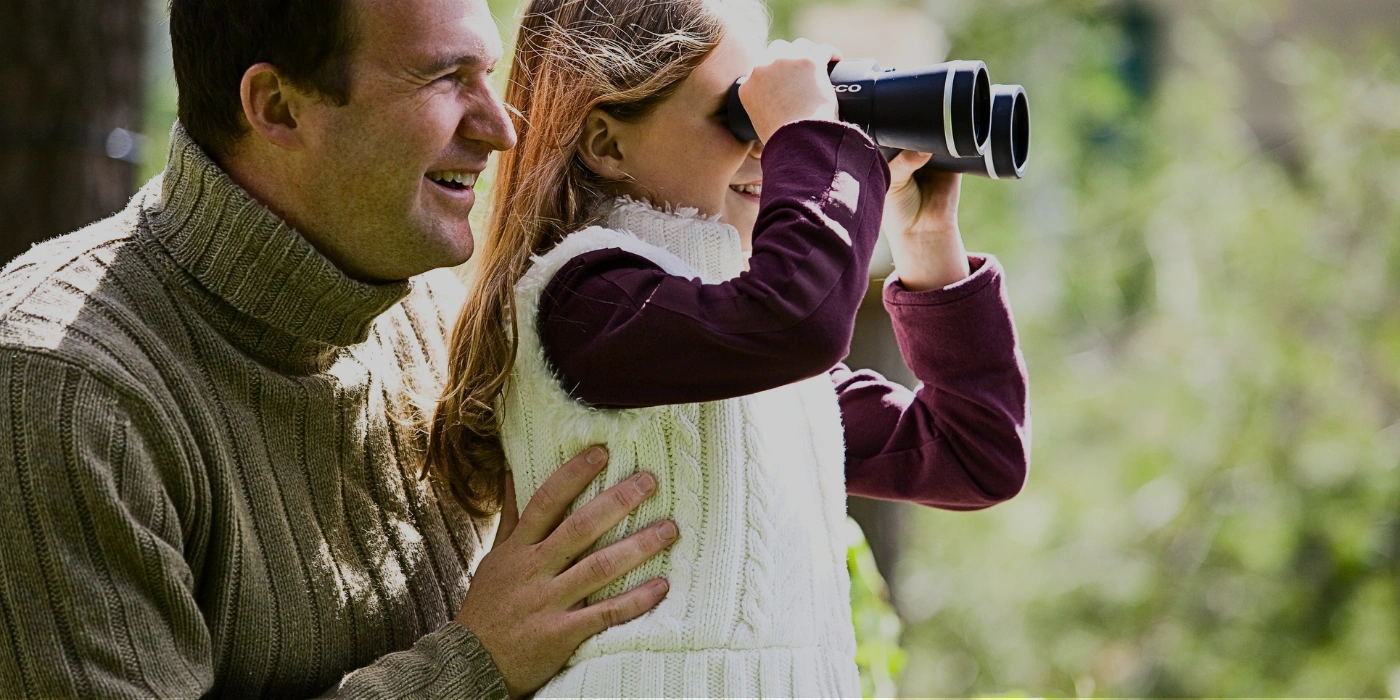 A father and daughter birdwatching together in the lush greenery of Tabin Wildlife Reserve