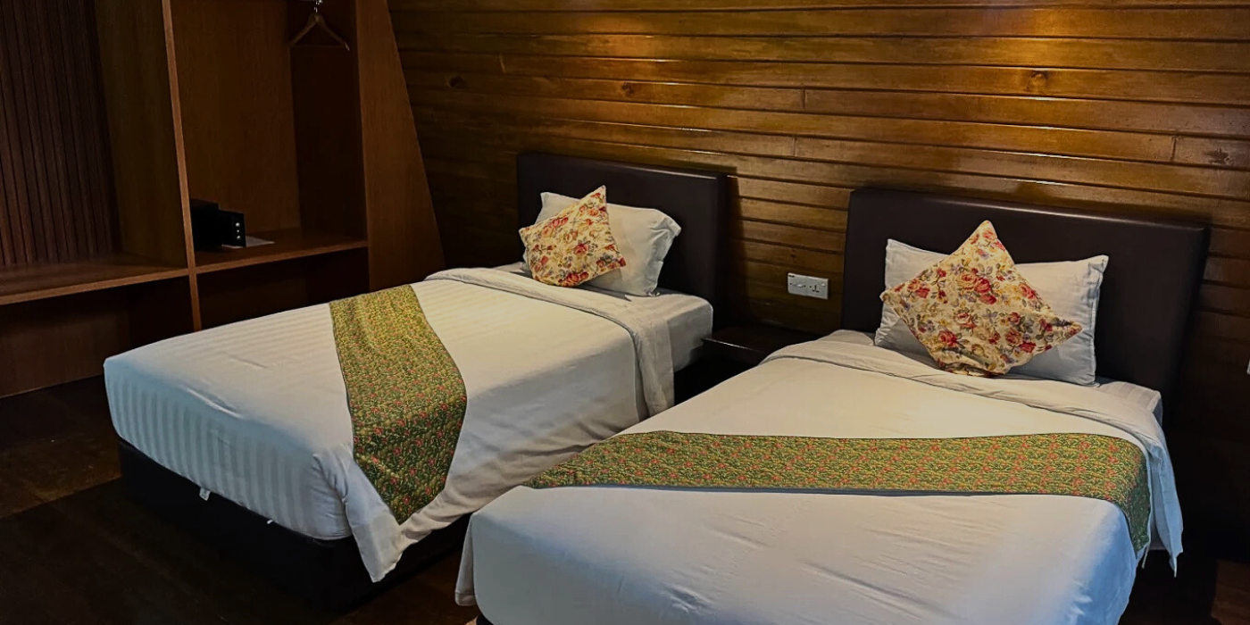 Interior of Tabin Wildlife Resort room with two single beds, & wooden furnishings